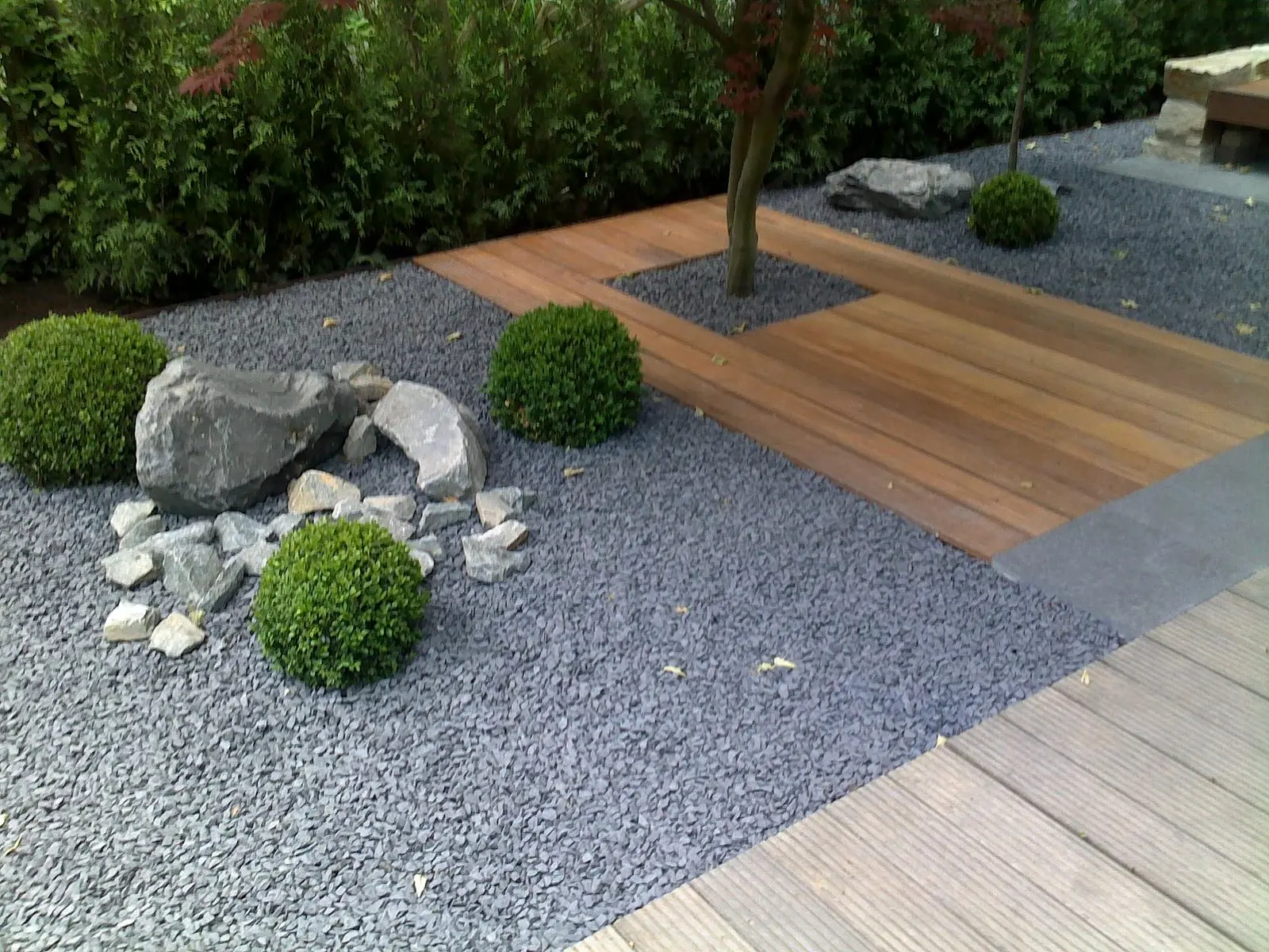 Geradlinige Natursteinplatten durch einen modernen Garten