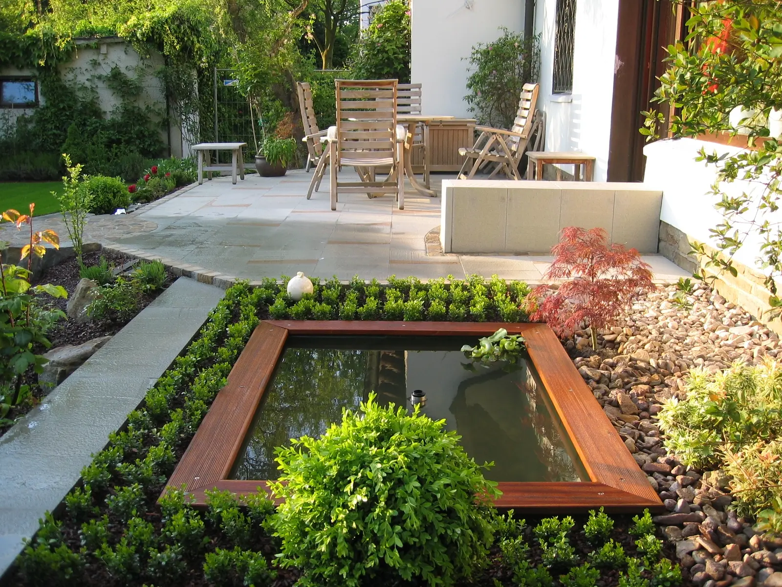 Quadratisches Wasserbecken mit Cortenstahlrand an einer Terrasse