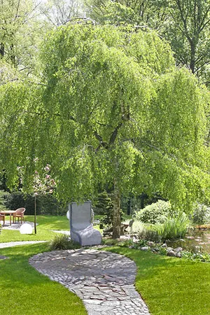 Asiatische Gartenskulptur zwischen Pflanzen