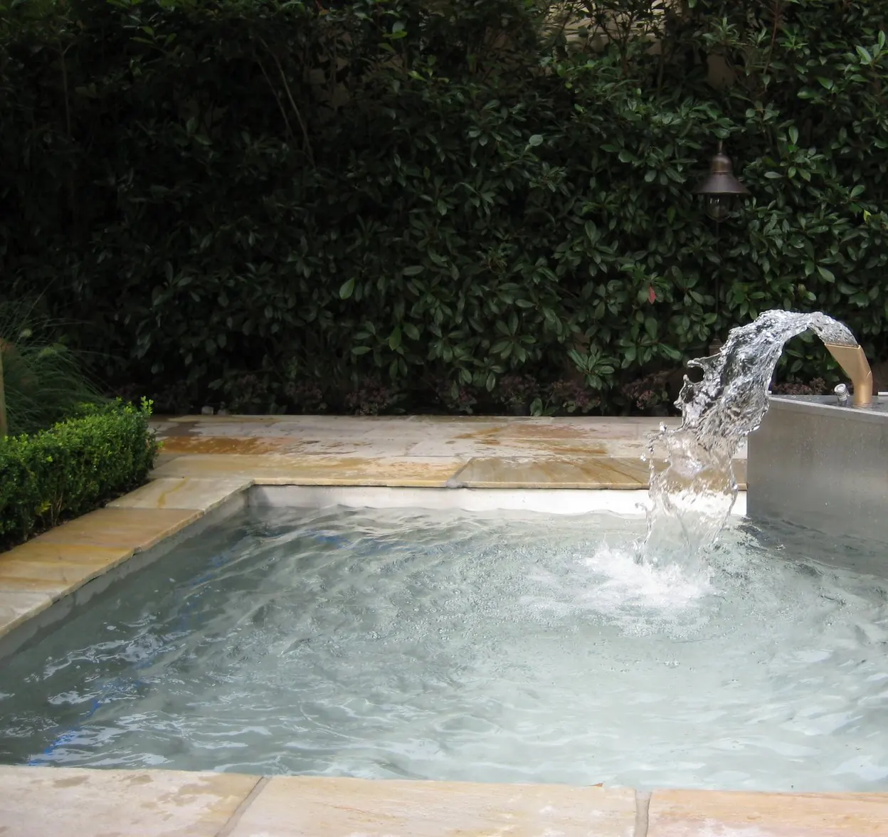 Wasserstrahl in einem Natursteinbecken