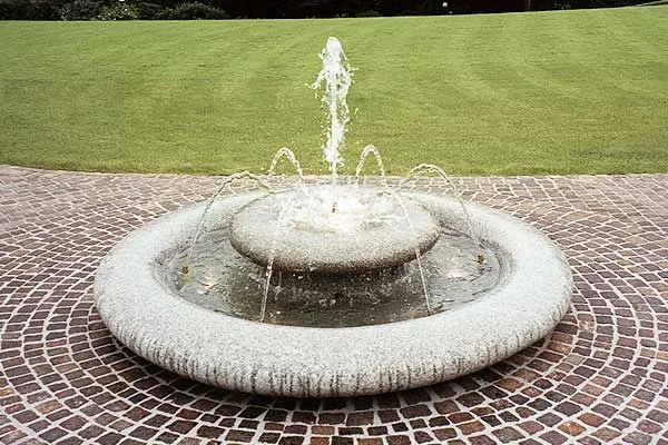 Runder Schalenbrunnen auf Mosaikpflaster