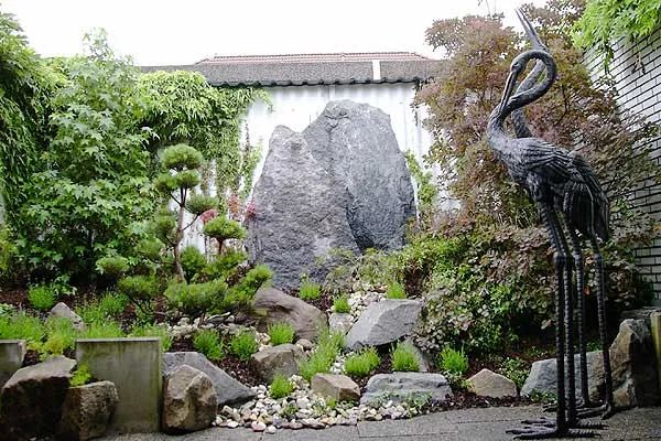 Japanisch geprägter Garten mit Stein und Figur